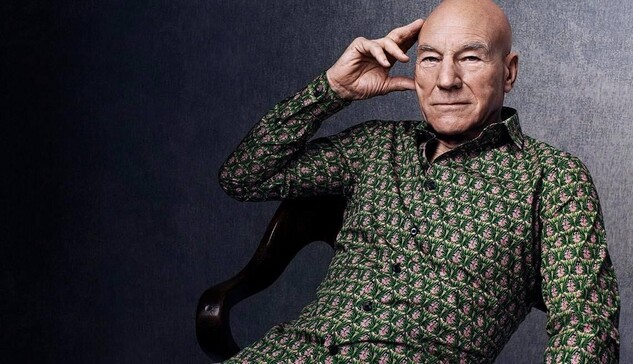 Sir Patrick Stewart wearing a patterned green button-up shirt, lounging alluringing in an armchair