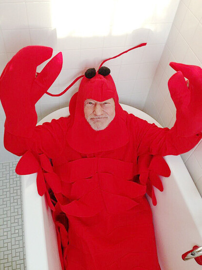 Sir Patrick Stewart dressed in a lobster costume laying in a bathtub
